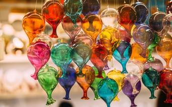 Hängende Ausstellung bunter Muranoglas-Ornamente in Tropfenform mit leuchtenden roten, blauen, grünen, gelben und violetten Farbtönen in Venedig.