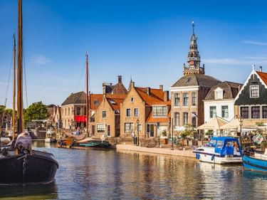 Historischer Hafen von Monnickendam mit traditionellen niederländischen Häusern, roten Ziegeldächern, Booten und dem Turm der Lutherse Kirche.