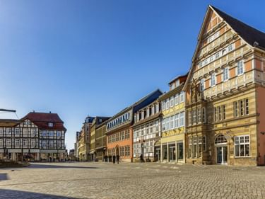 Kopfsteinpflasterplatz in Hamelns Altstadt mit bunten Fachwerk- und Renaissancegebäuden unter blauem Himmel.